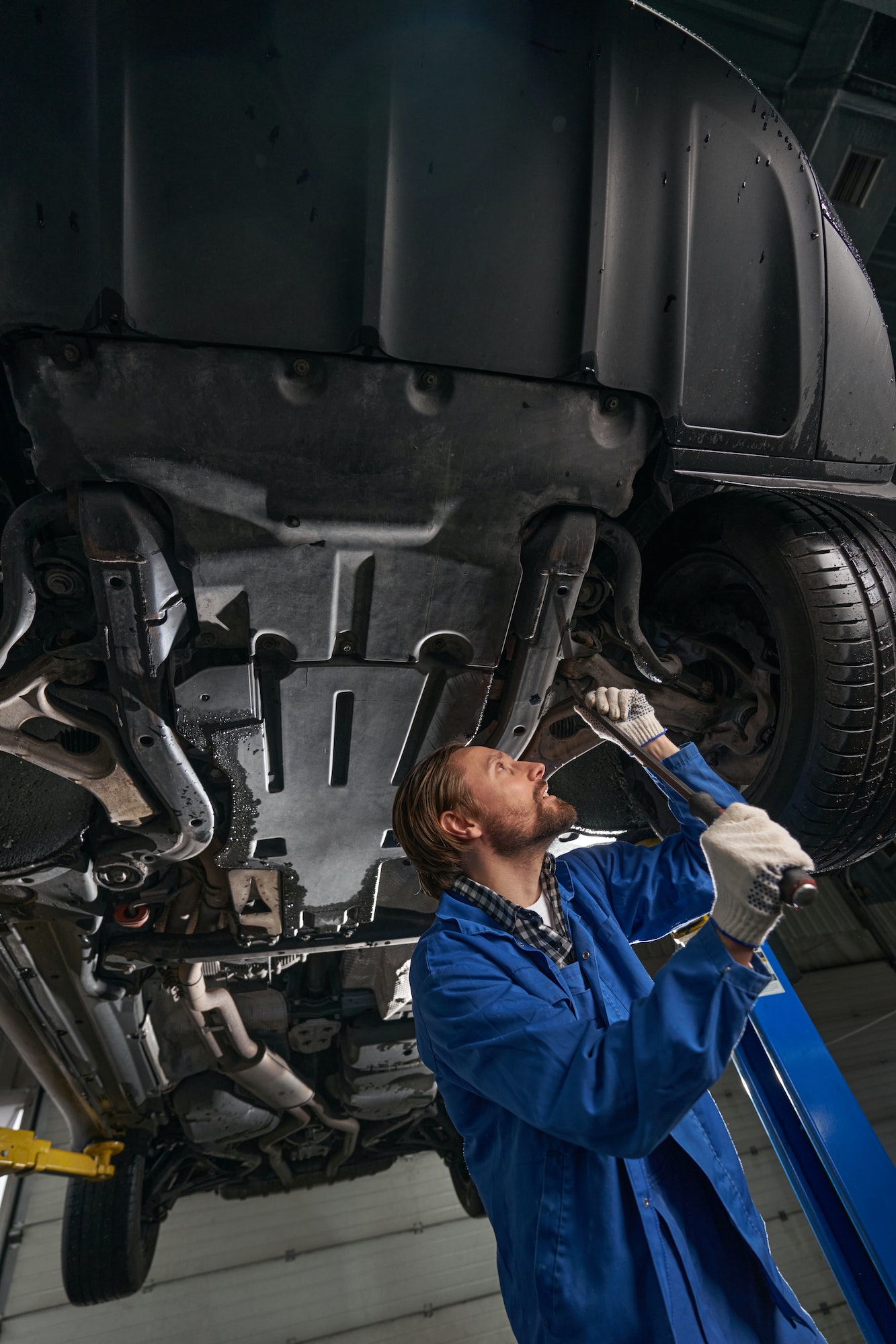 At service station male working and repairing car